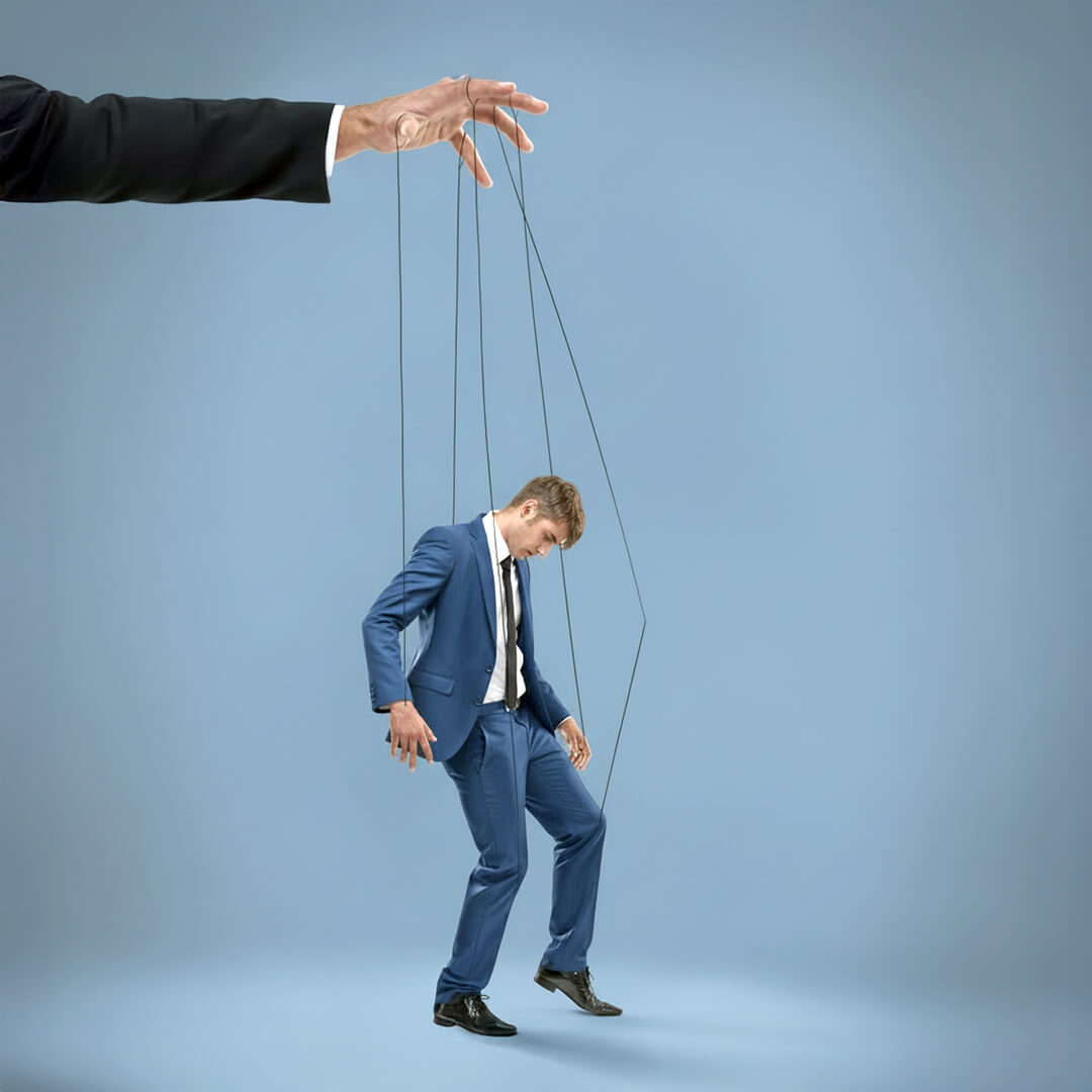 A man in a suit is being pulled by puppet strings.